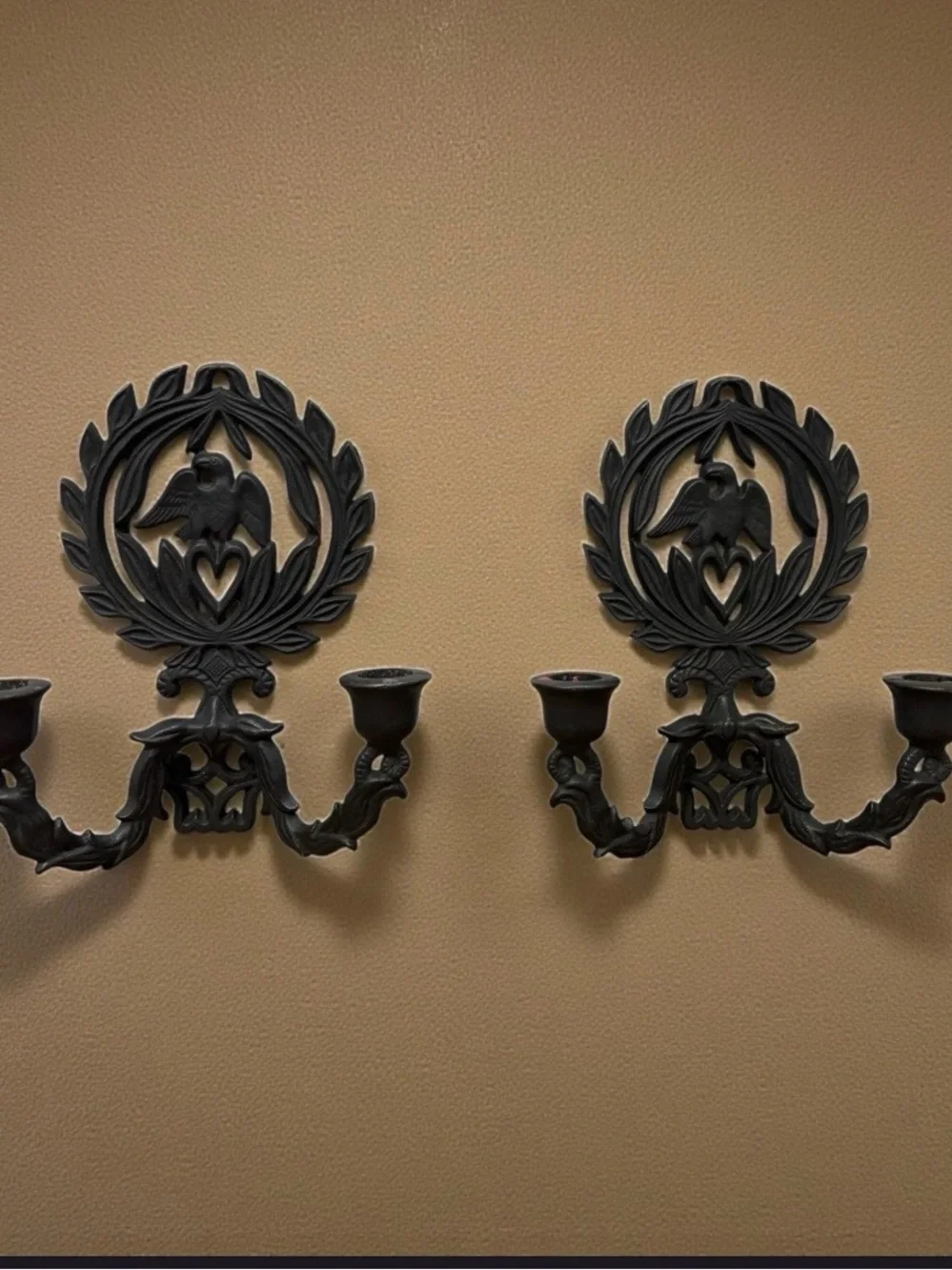 A pair of vintage cast iron wall sconces with eagle and laurel wreath motif